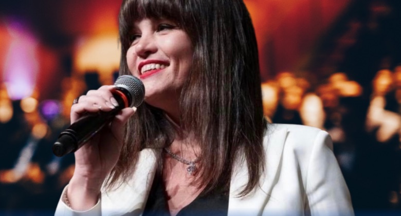 Emanuela Mencarelli sorride sul palco con il microfono in mano